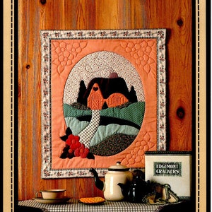 May include: A quilt pattern for a country cottage wall hanging. The quilt is 21 1/2 inches by 25 1/2 inches and features a red and white house with a green lawn and a white picket fence. The quilt is surrounded by a peach-colored border with a floral pattern. The pattern is titled "Country Cottage" and is from Calico Hills Farm, copyright 1985.