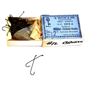 May include: A box of Mustad-Carlisle hooks, size 12, with a blue and white label. The box is labeled "Superior" and "Made in Norway".