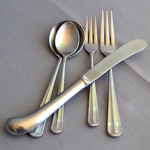 May include: A set of silver cutlery, including a butter knife, two forks, and two spoons.