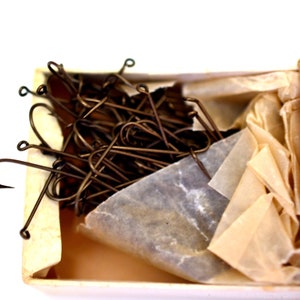 May include: A box of 100 brass fishing hooks, wrapped in tissue paper. The box is blue with white snowflakes and the text "Key Brand" and "100 No. 6".