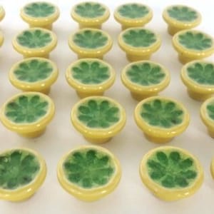 Peut inclure: Trente-six boutons de tiroir en céramique jaune avec des motifs floraux verts.