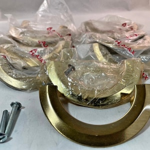 May include: A pack of eight gold-toned cabinet door pulls with a rounded, arched design. The pulls are packaged in clear plastic bags and include screws for installation.