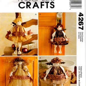 May include: A sewing pattern for four different angel dolls. Each doll is dressed in a different color and has a different word on its banner: Joy, Hope, Freedom, and Peace. The pattern is from McCall's Crafts and is number 4267.