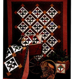 May include: A quilt pattern called "Pine Grove" featuring a design of stylized pine trees in shades of brown, green, and blue. The quilt is surrounded by a red and white gingham border. The pattern is from Thimbleberries, a quilting company located in Hutchinson, Minnesota.