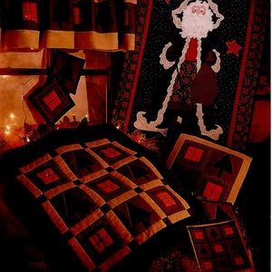May include: A quilt pattern featuring a cabin with lit windows, a Christmas tree, and a Santa Claus figure. The pattern is titled "90201 CABIN LIGHTS" and is from Fiber Mosaics.