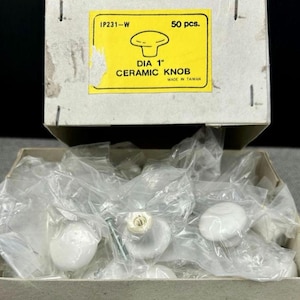 May include: A box of white ceramic knobs, each 1 inch in diameter, with screws. The box has a yellow label that reads "DIA 1" CERAMIC KNOB" and "50 pcs." The box is labeled "IP231-W" and "MADE IN TAIWAN".