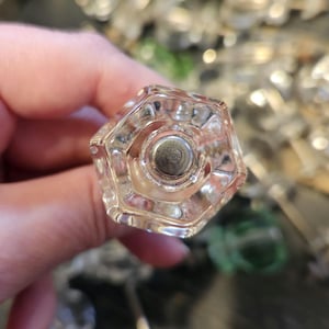May include: A clear glass doorknob with a hexagonal shape and a silver metal insert in the center.