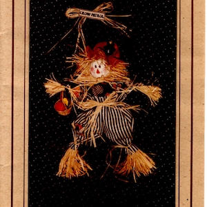 May include: A craft pattern for a scarecrow doll with a black and white striped outfit and a straw hat. The pattern is titled "#191 PATCHES" and includes the text "Happiness is Homemade".