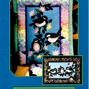 May include: A quilt pattern titled "Chickadees x Three" featuring a central image of three chickadees perched on branches with pink and yellow flowers. The quilt measures 25 1/2 inches long and 26 1/2 inches wide. The pattern is by Pine Meadows Designs.