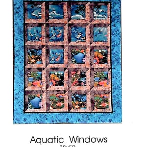 May include: A quilt pattern called "Aquatic Windows" with a blue border and a grid of 16 squares. Each square features a different underwater scene with coral, fish, and seaweed.