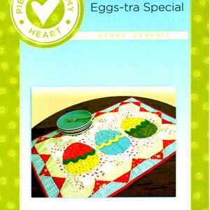 May include: A quilted table runner with a red, white and blue patchwork design. Three colourful Easter eggs are appliqued on the runner. The text "Eggs-tra Special" is printed on the image.