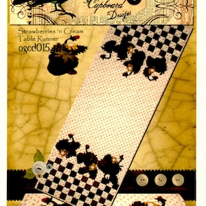 May include: A table runner with a checkered pattern and a design of strawberries and leaves. The runner is made of fabric and has a vintage look. The text "Strawberries 'n Cream Table Runner ogcd015" is printed on the runner.