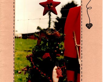 May include: A red and white star-shaped Christmas ornament hangs from a small, decorated Christmas tree. The tree is decorated with red and white ornaments, including a fish-shaped ornament. The image is titled "Reelin' in the Holidays" and "from Hanging by a Thread by Connie's Calicos, Too".