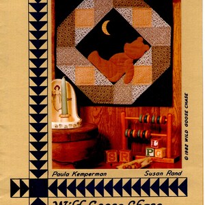 May include: A quilt pattern for a lonely teddy bear, featuring a brown teddy bear with a crescent moon in the background. The pattern is part of the Primitive Folk Art Collection, #801, by Wild Goose Chase. The pattern is 18 inches.