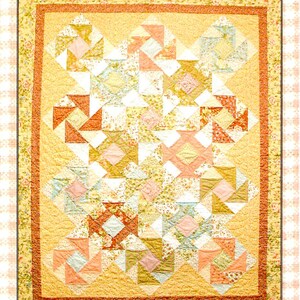 May include: A quilt with a patchwork design featuring a variety of floral prints in shades of pink, orange, and yellow. The quilt is bordered with a solid yellow fabric and a floral print fabric.
