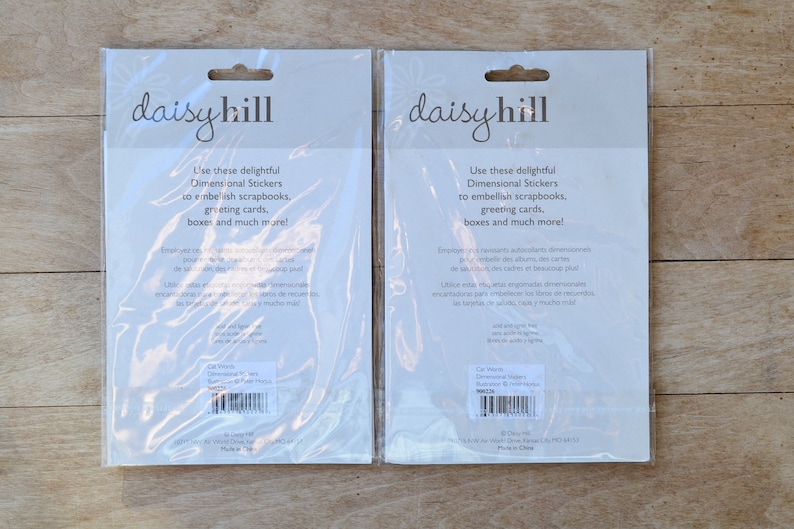 May include: Two packages of Daisy Hill Dimensional Stickers. The white packages have a black and white design with the text "Use these delightful Dimensional Stickers to embellish scrapbooks, greeting cards, boxes and much more!"