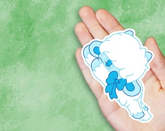May include: A blue and white cartoon sticker of a fluffy sheep with a blue bow. The sheep is curled up and has its eyes closed.