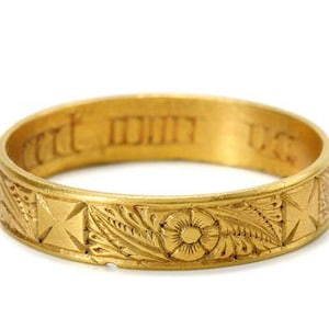 Pu&ograve; includere: Un anello a fascia d'oro con intricati disegni floreali e a croce. L'iscrizione "mit dir" &egrave; incisa all'interno della fascia.