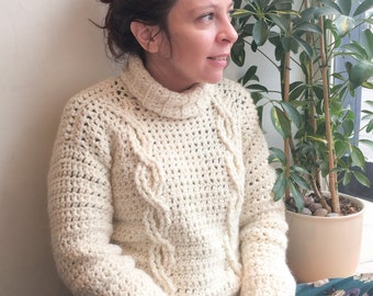 May include: A white crocheted sweater with a cable knit pattern. The sweater has a turtleneck and long sleeves.