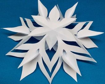 May include: A white paper snowflake with intricate cutouts, against a bright blue background.
