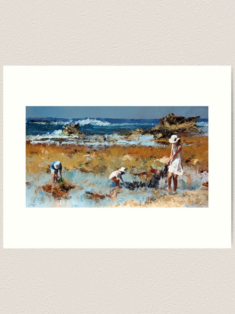 May include: A painting of a beach scene with three people in the foreground. Two children are bending over, looking at something on the ground, while a woman in a white dress and hat stands nearby. The ocean is in the background, with waves crashing on the shore.