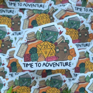 May include: A white sticker featuring a colourful illustration of a collection of fantasy role-playing game items, including dice, a potion bottle, a book, and a bag. The text "Time to Adventure" is printed on the sticker.
