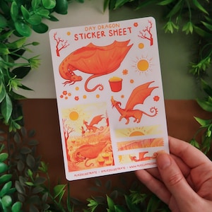 Może przedstawiać: Arkusz naklejek z pomarańczowymi ilustracjami smoków. Tekst "DAY DRAGON STICKER SHEET" znajduje się na górze. Arkusz zawiera różne wzory smoków, słońca i sceny krajobrazowe. Nazwa i strona internetowa artysty znajdują się na dole.