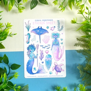 May include: A sticker sheet with illustrations of mermaids and marine life. The design includes a seahorse, stingray, jellyfish, and a turtle. The text "Coral Mermaids Sticker Sheet" is displayed at the top of the sheet.
