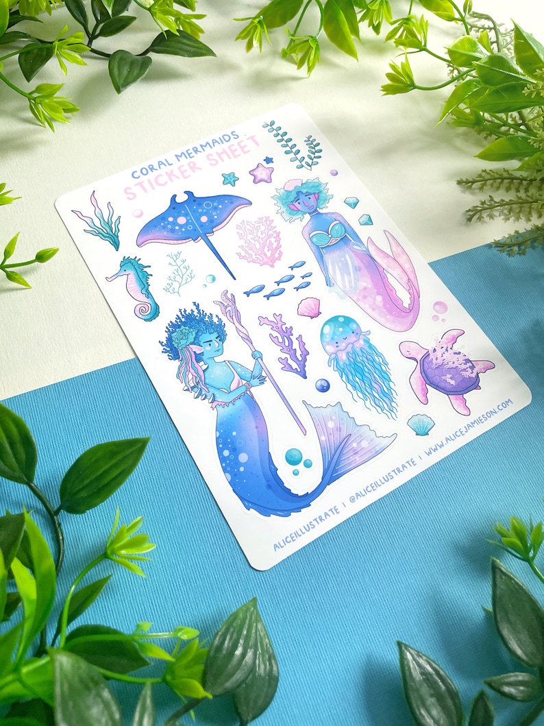 May include: A sticker sheet labelled "Coral Mermaids" with illustrations of mermaids and marine life. The mermaids are in blue and purple hues, with detailed fins and hair. Other sea creatures include a stingray, seahorse, and jellyfish, with coral accents.