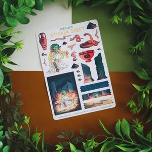May include: A sticker sheet featuring illustrations of Medusa and related imagery. The sheet includes images of snakes, a red vase, and a depiction of Medusa in a temple. The text "MEDUSA STICKER SHEET" is at the top. The background is a mix of green, white, and brown.
