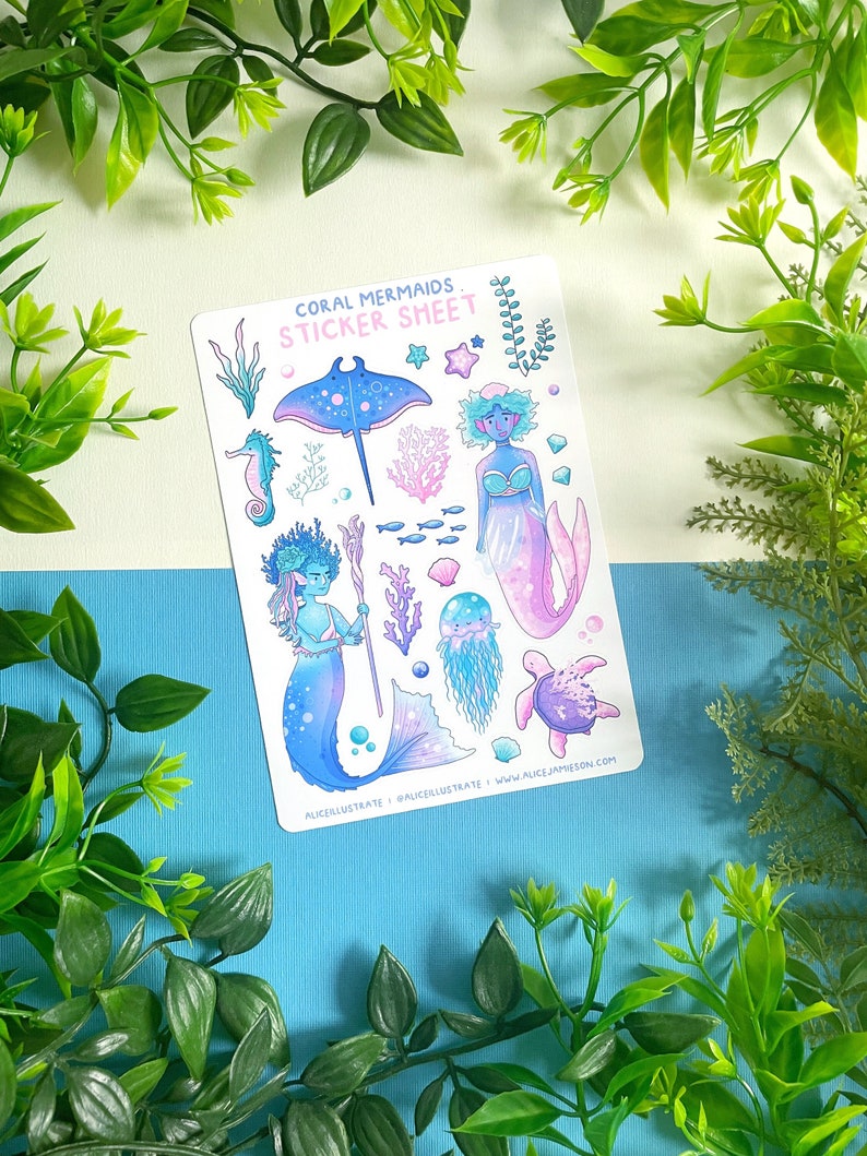 May include: A sticker sheet with illustrations of mermaids and marine life. The design includes a stingray, seahorse, jellyfish, and a turtle, alongside various mermaid characters. The text "Coral Mermaids Sticker Sheet" is printed at the top of the sheet.