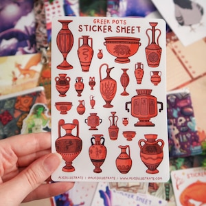 Puede incluir: Una hoja de pegatinas con ilustraciones de vasijas griegas rojas y marrones. La hoja muestra una variedad de jarrones, cuencos y ánforas. El texto "GREEK POTS STICKER SHEET" está en la parte superior. El nombre y el sitio web del artista están en la parte inferior.