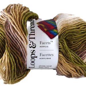 Puede incluir: Una madeja de hilo acr&iacute;lico Loops & Threads Facets con una paleta de colores variados en tonos verde oliva, marr&oacute;n y crema. La etiqueta blanca del producto muestra la marca, el texto Facets Acrylic y 256M / 100 G.