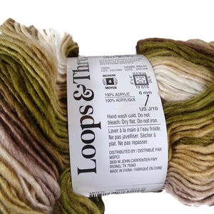 Puede incluir: Una madeja de hilo Loops & Threads de peso medio 4 en una combinaci&oacute;n de colores variados de verde oliva, marr&oacute;n y crema. La etiqueta de papel indica material 100% acr&iacute;lico, tama&ntilde;o de aguja de 6 mm, ganchillo US J/10 e instrucciones.