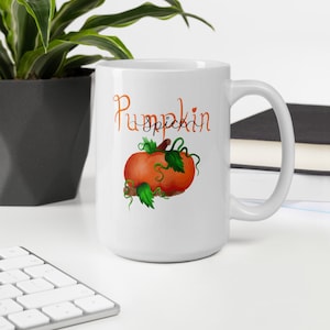 Könnte beinhalten: Weiße Keramiktasse mit einem Kürbisgewürz-Design. Die Tasse hat einen Henkel und zeigt einen handgemalten orangefarbenen Kürbis mit grünen Blättern und einem braunen Stiel. Der Text "Pumpkin Spice" ist in orangefarbener und schwarzer Kursivschrift geschrieben.