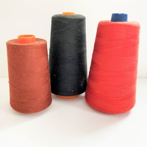 May include: Three spools of thread, one red, one black, and one brown.