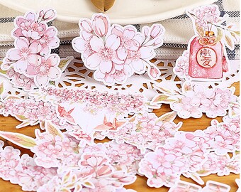May include: A set of pink and white floral stickers featuring cherry blossoms, leaves, and a small red envelope with the Chinese characters for "love" written on it.