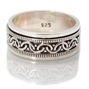 May include: A silver ring with a detailed, intricate design of interlocked circles and dots. The ring is marked with the number "925" on the inside.