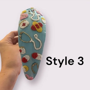 May include: A light blue headband with a beaded design featuring medical symbols like pills, stethoscopes, and bandages. The headband is decorated with red, yellow, white, and gold beads. The text "Style 3" is visible in the image.