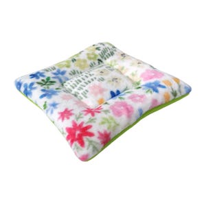 May include: A white and green floral patterned cushion with a soft, plush texture. The cushion is square shaped and has a green border.
