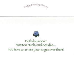 May include: A white birthday card with the text "Happy Birthday, Honey!" in purple script. The card features a small blue floral design and the message "Birthdays don't hurt too much, and besides... You have an entire year to get over them!" in green.