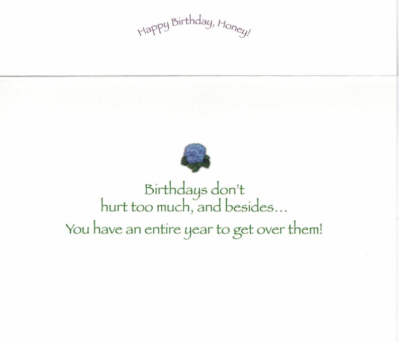 May include: A white birthday card with the text "Happy Birthday, Honey!" in purple script. The card features a small blue floral design and the message "Birthdays don't hurt too much, and besides... You have an entire year to get over them!" in green.