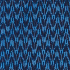 May include: A close-up of a fabric with a repeating zigzag pattern. The pattern features a combination of dark navy and bright blue, creating a textured, ikat-style design. The fabric's design is a visually striking, abstract pattern.