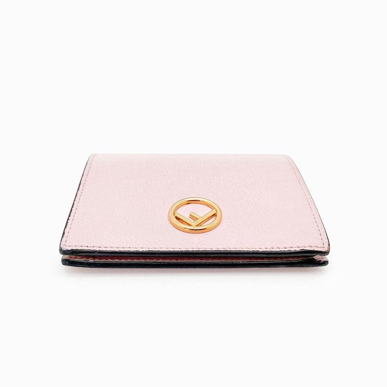 May include: A pale pink leather wallet with a gold Fendi logo.