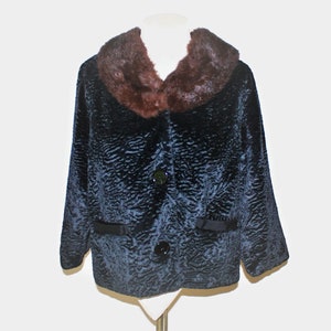 May include: A dark blue faux fur jacket with a brown faux fur collar. The jacket has a button closure and two pockets.