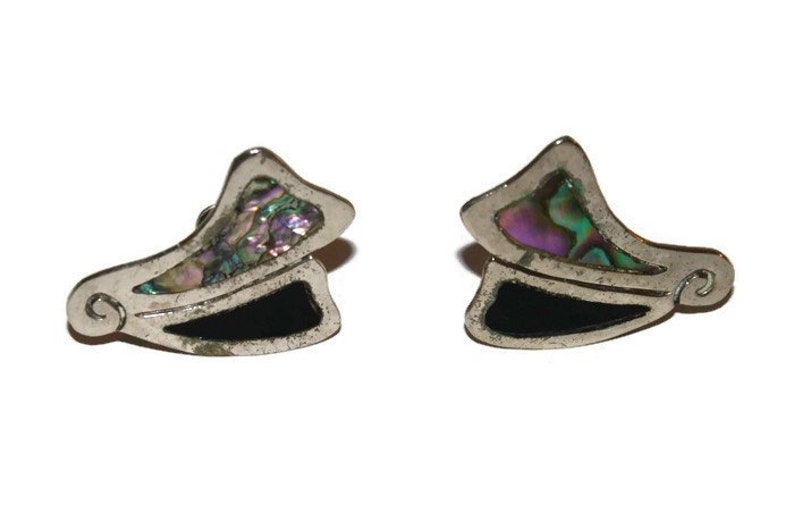 May include: A pair of silver earrings with a black and iridescent abalone shell design. The earrings are shaped like a wing or a leaf.