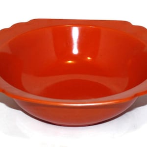 May include: A bright orange plastic bowl with a slightly scalloped rim.