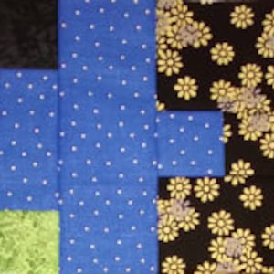 Puede incluir: Un edred&oacute;n de patchwork de forma rectangular, con varios patrones y colores de tela. El edred&oacute;n incluye secciones amarillas con dise&ntilde;os de plumas blancas, azules con lunares blancos, negras con estampados florales amarillos y rojas con estampados florales blancos. Tambi&eacute;n hay cuadrados negros y verdes.