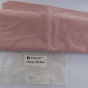 Puede incluir: Una muestra de tela rosa p&aacute;lido con una etiqueta blanca que dice "Fancy's Notions".