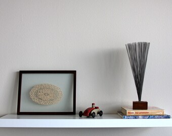 Vintage crocheted doily in a wood frame